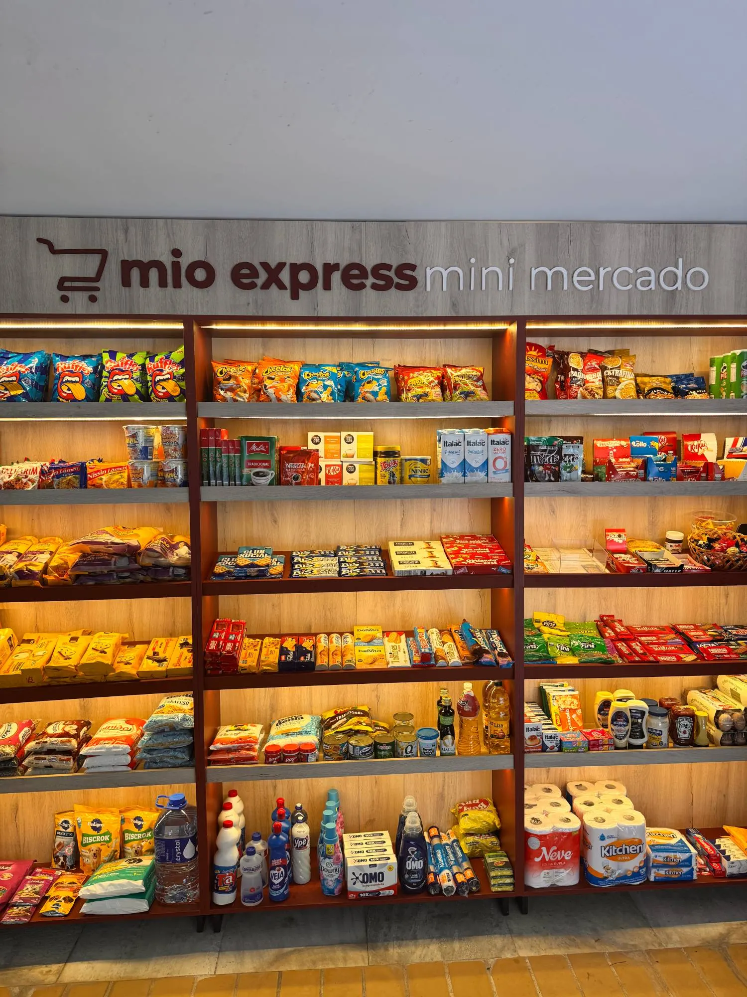 Prateleiras com snacks, mercearia, café e produtos de limpeza